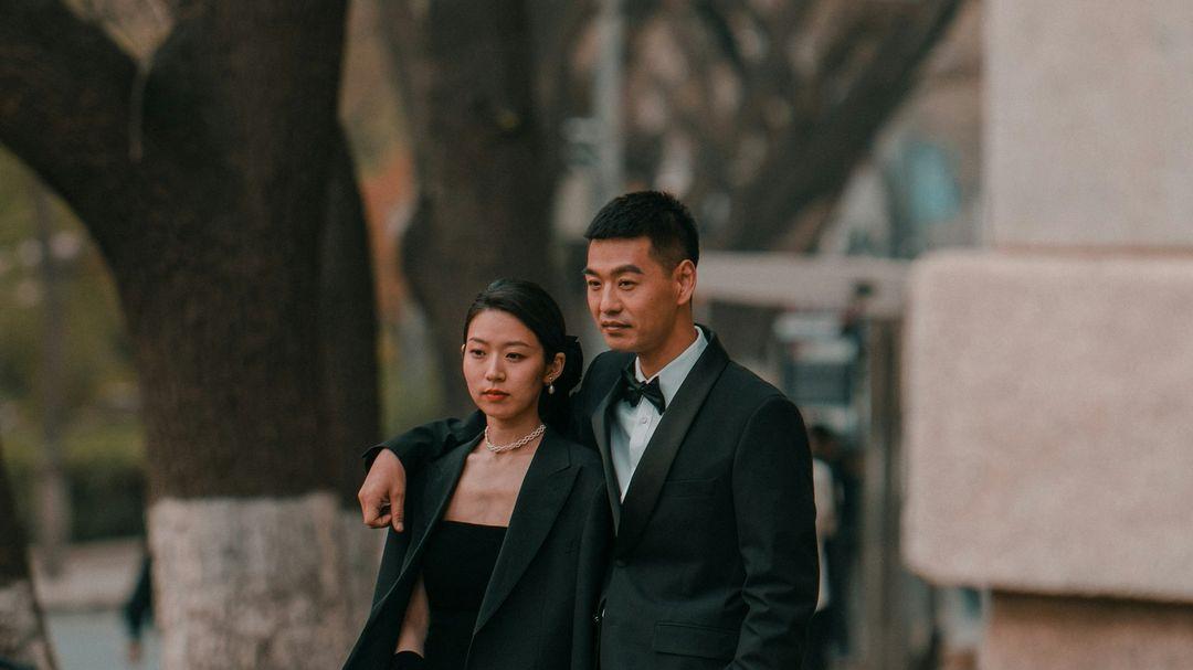 a man and a woman standing next to each other on a sidewalk